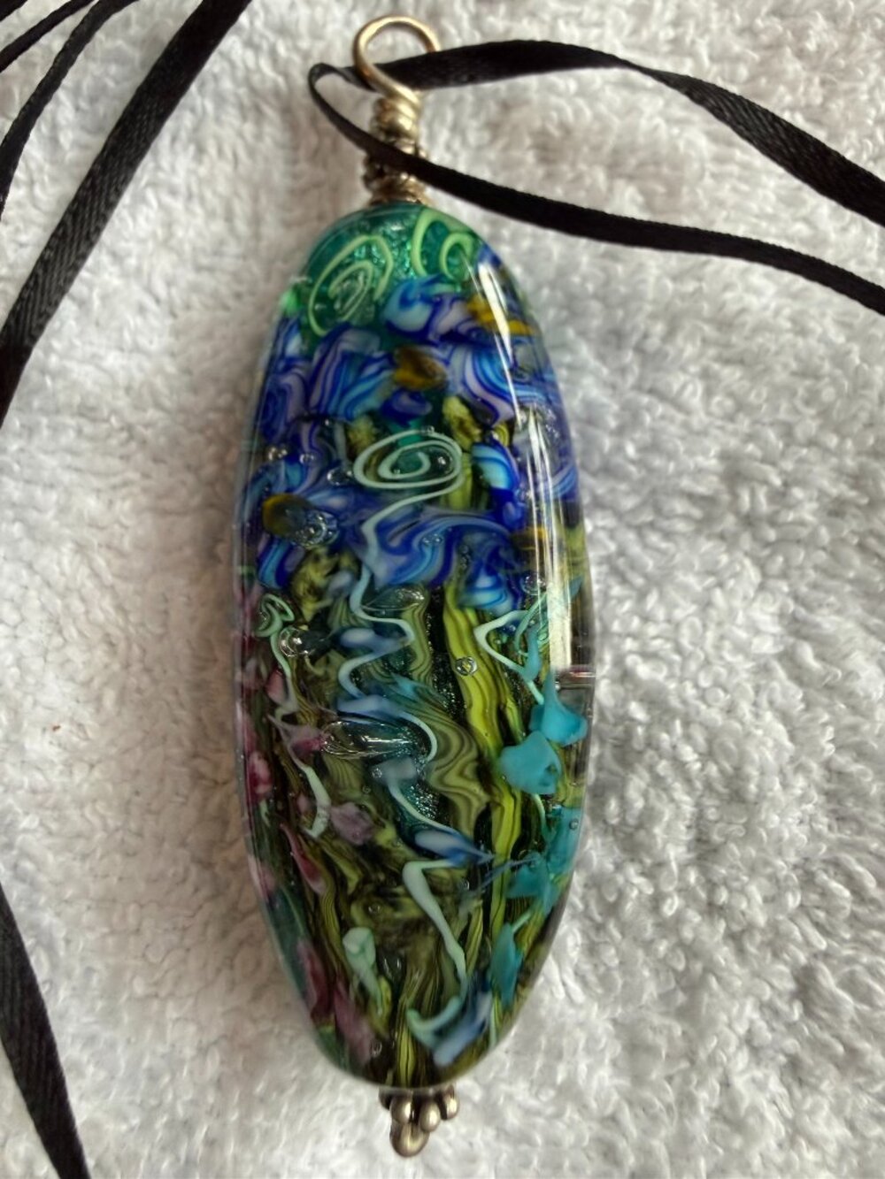 Glass pendant with intricate swirling pattern